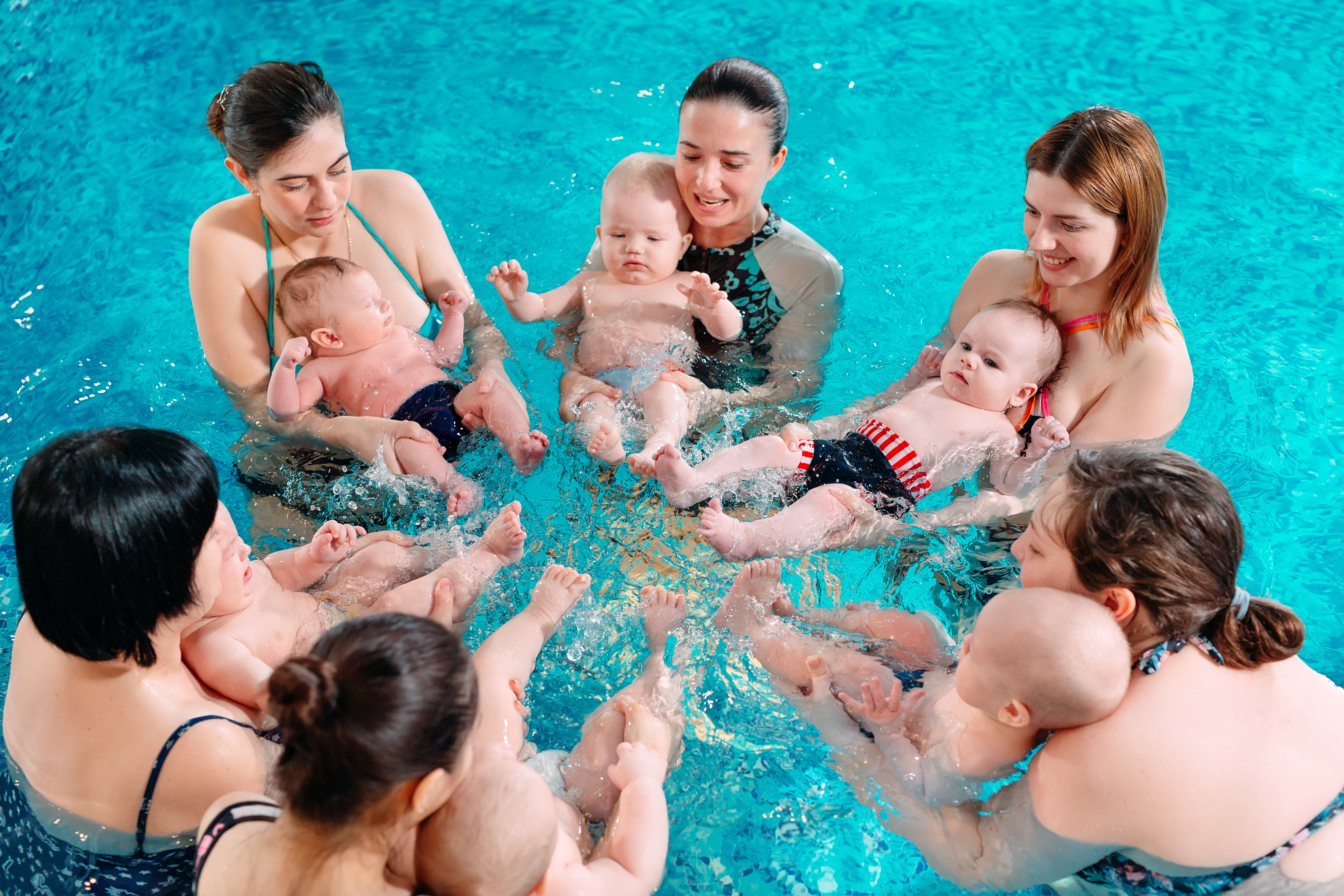 Familias participando en una actividad acuática para bebés